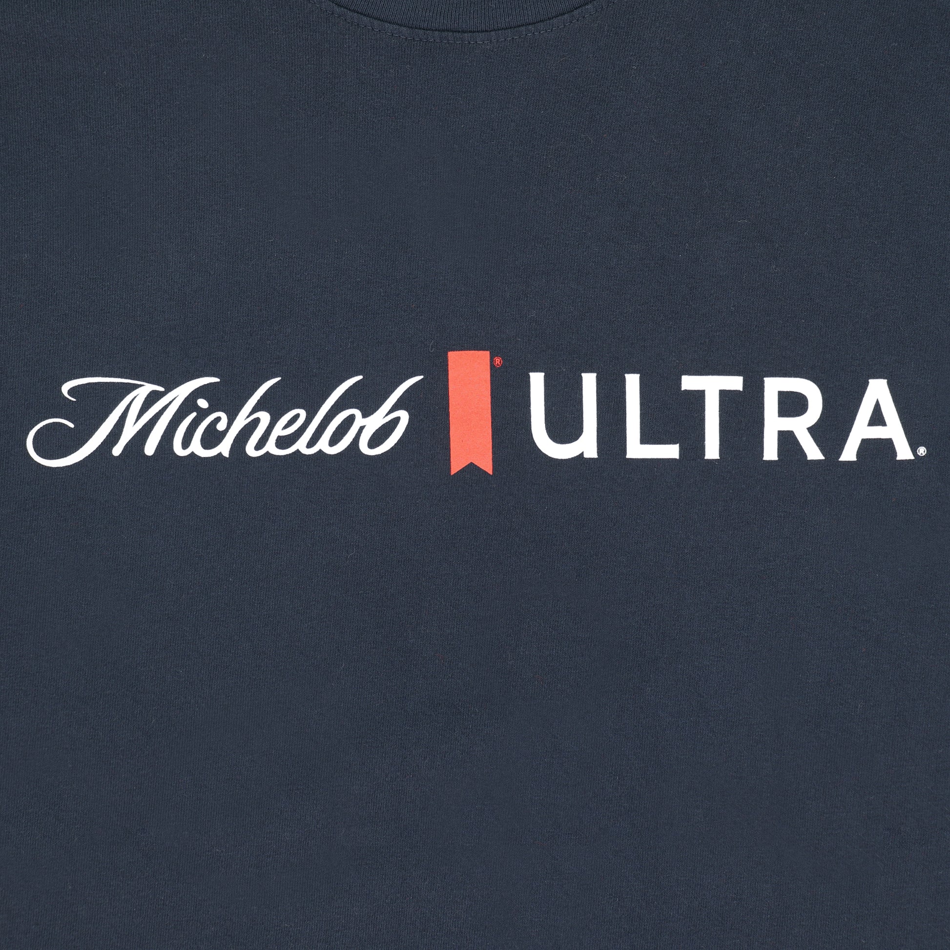 Close-up of logo on Michelob ULTRA Essentials Navy T-shirt